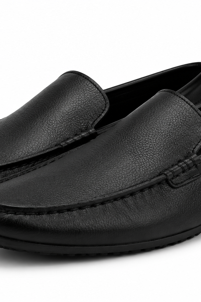 Pair of black leather loafers on a white background