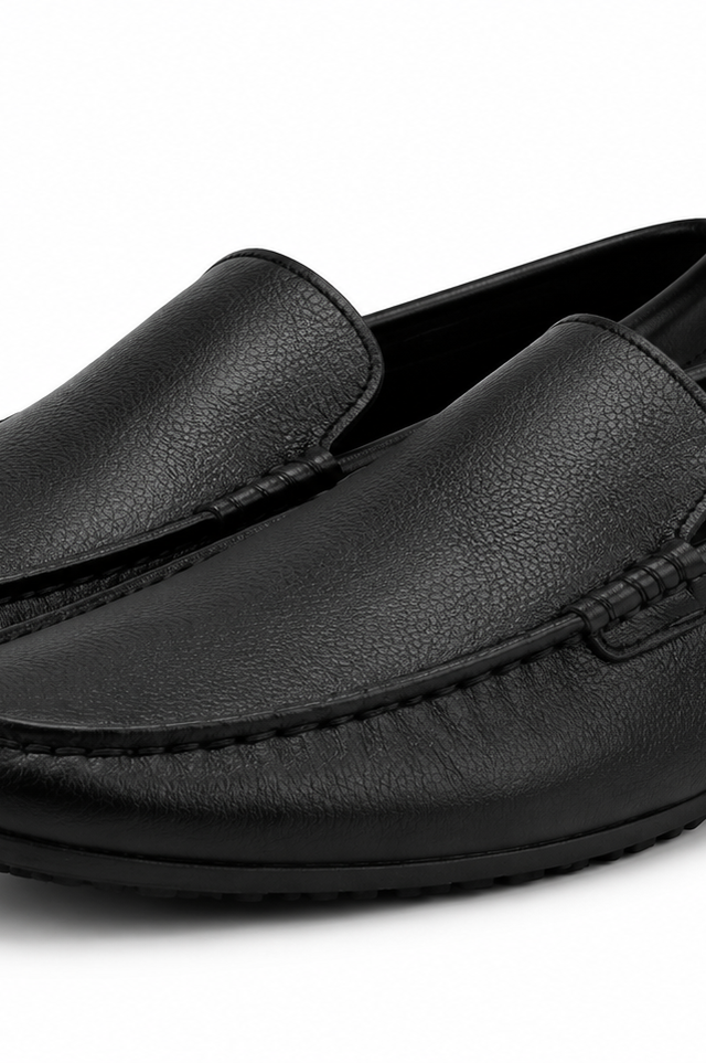 Pair of black leather loafers on a white background